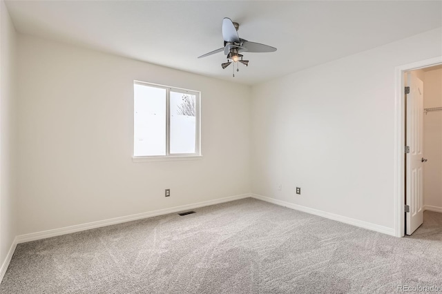 carpeted spare room with ceiling fan