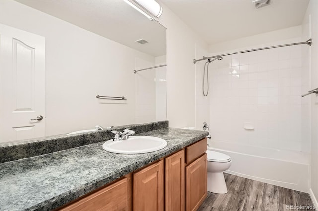 full bathroom with wood-type flooring, vanity, toilet, and tiled shower / bath combo