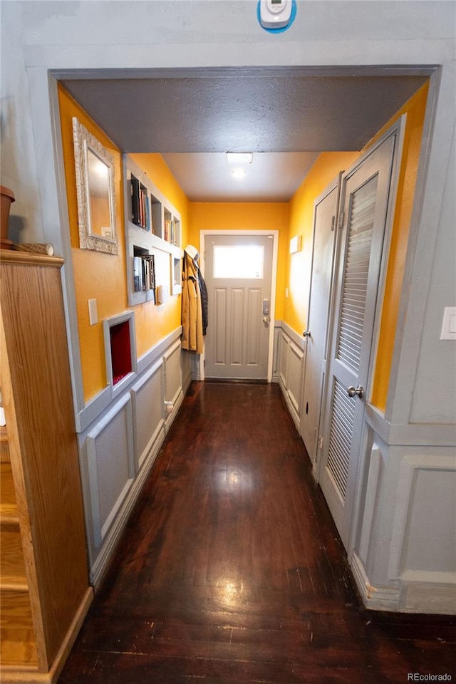 corridor with a textured ceiling and dark wood-type flooring