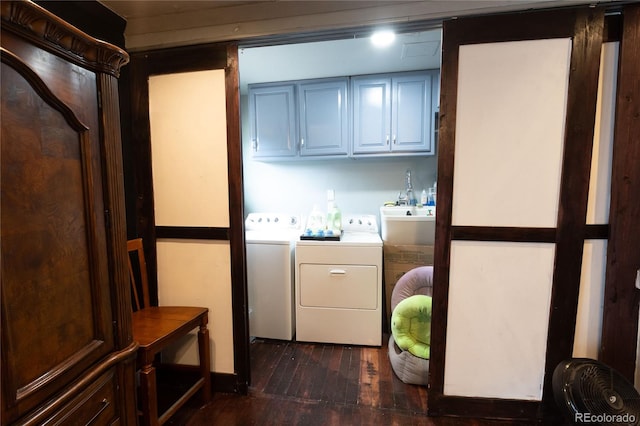 laundry room featuring washing machine and clothes dryer, dark wood-type flooring, and cabinets