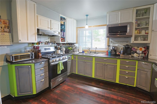 kitchen featuring pendant lighting, white cabinets, sink, appliances with stainless steel finishes, and dark wood-type flooring