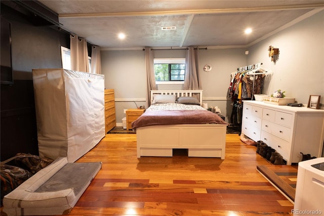 bedroom with light hardwood / wood-style flooring and ornamental molding