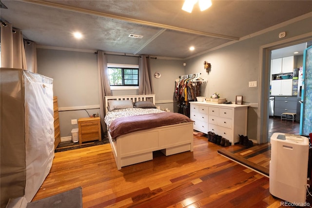 bedroom with ornamental molding and light hardwood / wood-style flooring