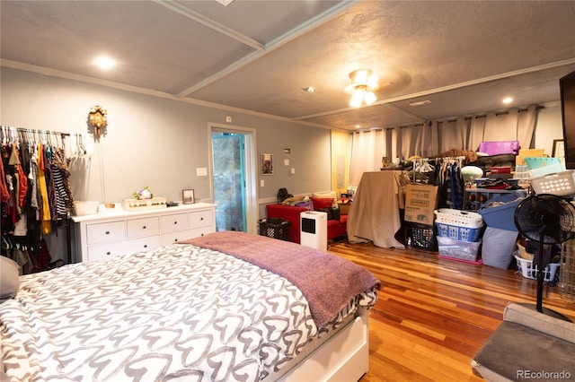 bedroom featuring a textured ceiling, light wood-type flooring, and ornamental molding