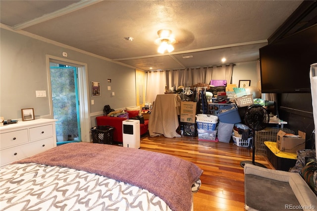 bedroom with crown molding, a textured ceiling, and light hardwood / wood-style floors