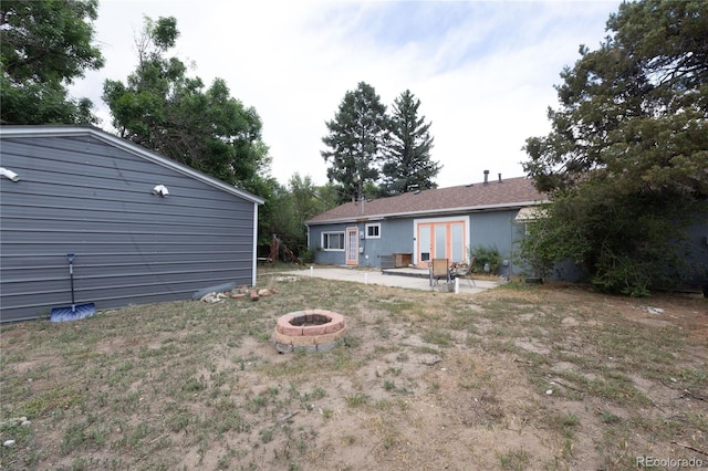 view of yard with a patio, french doors, and an outdoor fire pit