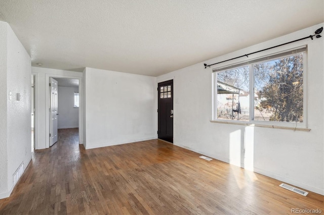 foyer entrance featuring hardwood / wood-style flooring and a textured ceiling