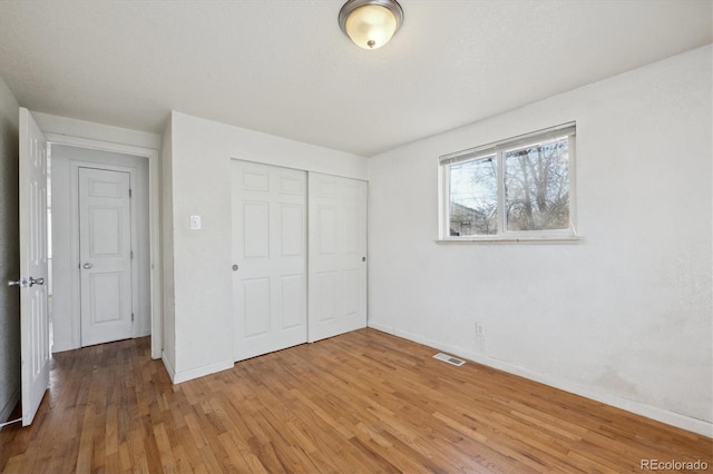 unfurnished bedroom featuring hardwood / wood-style flooring and a closet