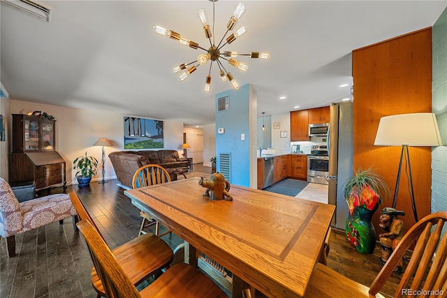 dining room featuring light wood finished floors, visible vents, baseboards, a chandelier, and recessed lighting