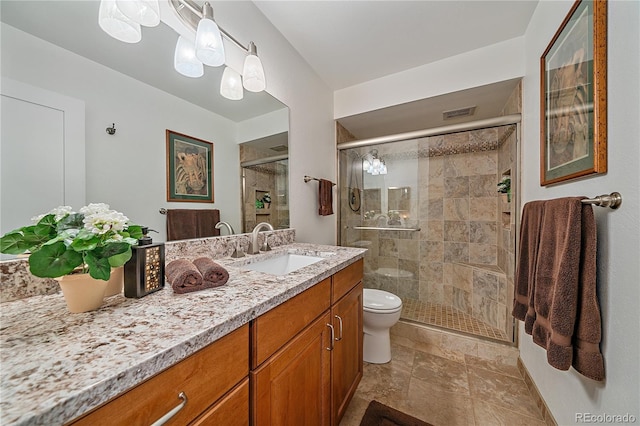 bathroom featuring toilet, a shower stall, and vanity