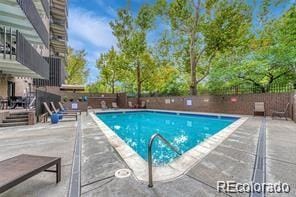 community pool featuring a patio and fence