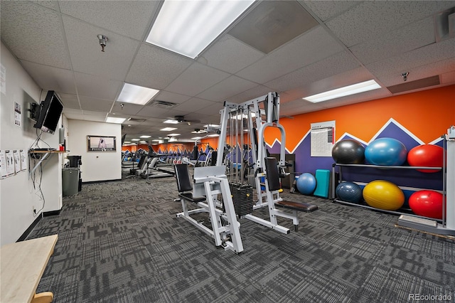 workout area featuring a paneled ceiling, visible vents, baseboards, and carpet flooring