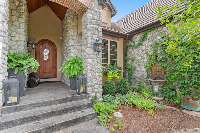doorway to property featuring stone siding