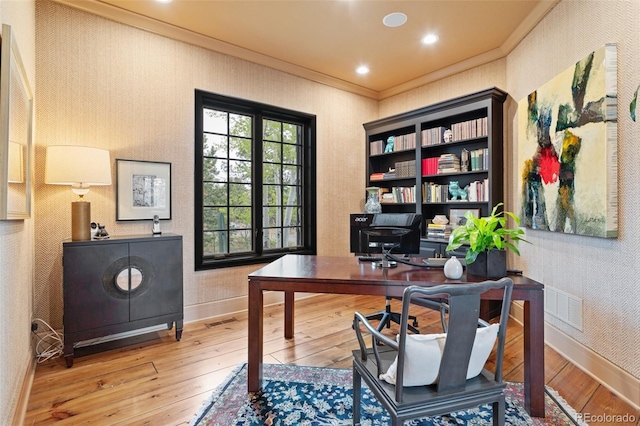 office with wood-type flooring, baseboards, visible vents, and ornamental molding