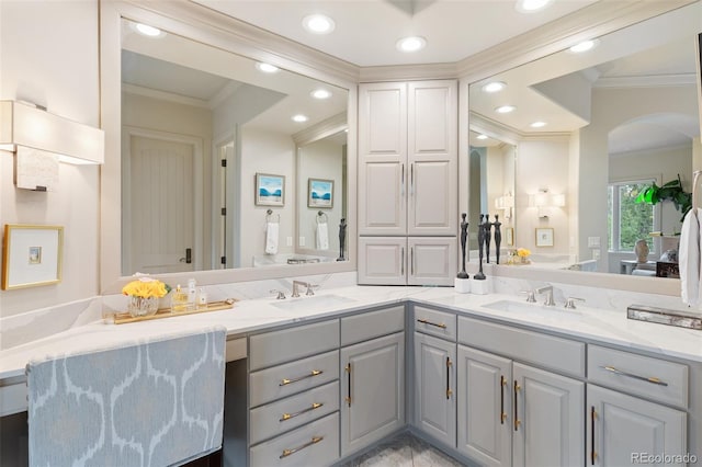 bathroom featuring crown molding, a sink, and double vanity