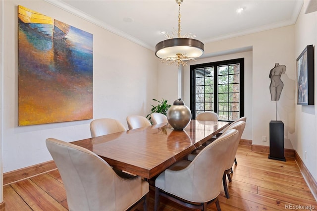 dining space with light wood-type flooring, ornamental molding, and baseboards
