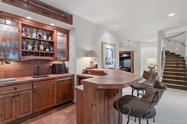 bar featuring backsplash, a sink, stairway, indoor wet bar, and recessed lighting