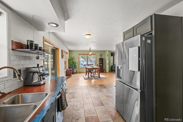 2476 S Beaver Creek Rd, Black Hawk, CO 80422 - kitchen featuring appliances with stainless steel finishes, a sink, tasteful backsplash, a textured ceiling, and hanging light fixtures