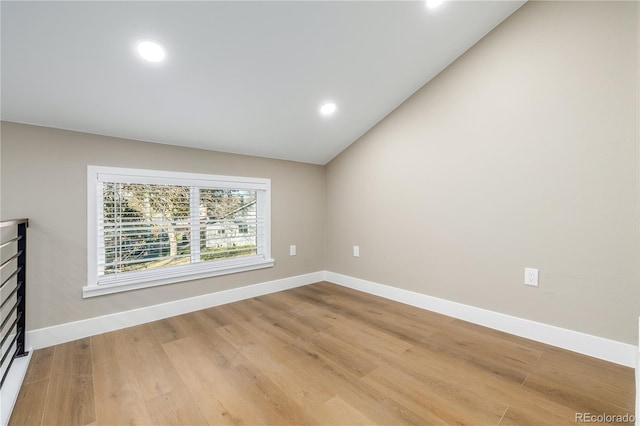 unfurnished room featuring hardwood / wood-style flooring and vaulted ceiling