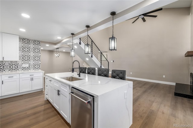 kitchen featuring pendant lighting, backsplash, white cabinetry, and sink