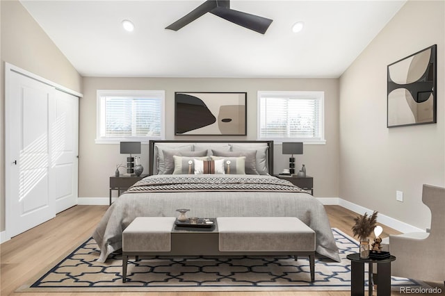 bedroom with multiple windows, hardwood / wood-style floors, vaulted ceiling, and ceiling fan