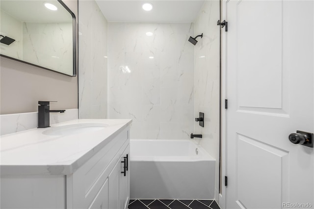 bathroom with tile patterned flooring, vanity, and tiled shower / bath