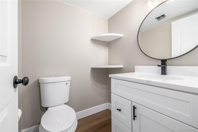 bathroom featuring vanity, wood-type flooring, and toilet