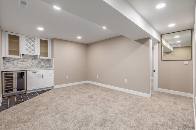 bar with backsplash, wine cooler, white cabinetry, and dark colored carpet