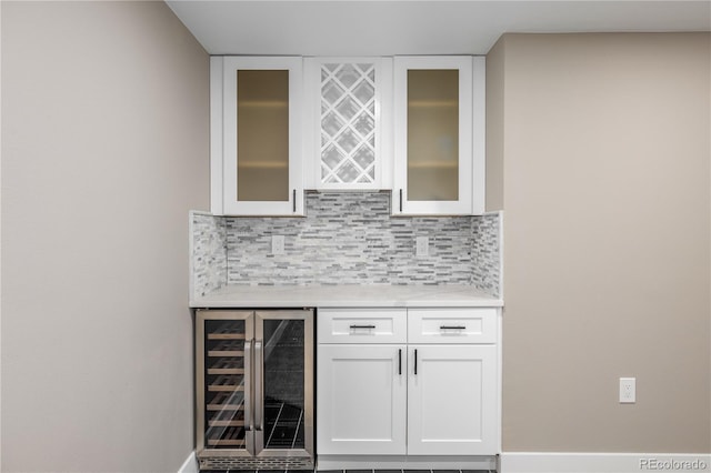 bar with white cabinetry, beverage cooler, and tasteful backsplash