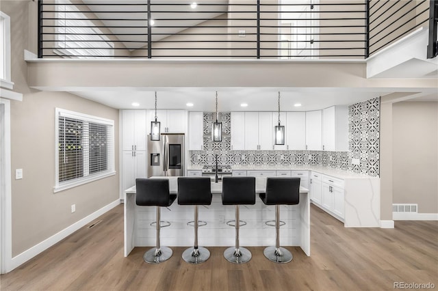 kitchen with white cabinetry, a breakfast bar, pendant lighting, and appliances with stainless steel finishes