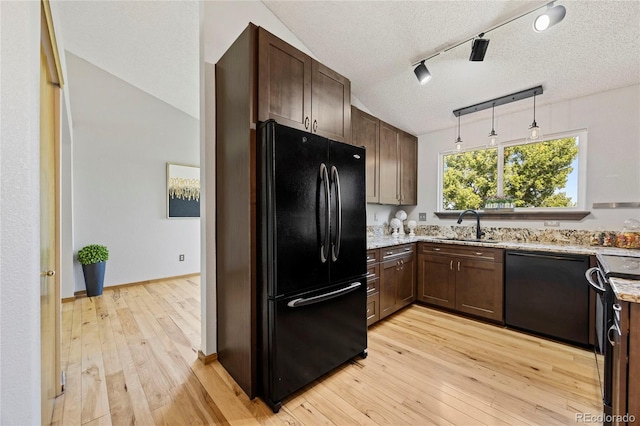 7345 W 97th Pl, Broomfield, CO 80021 - kitchen with black appliances, light wood-style flooring, light stone counters, dark brown cabinetry, and a textured ceiling