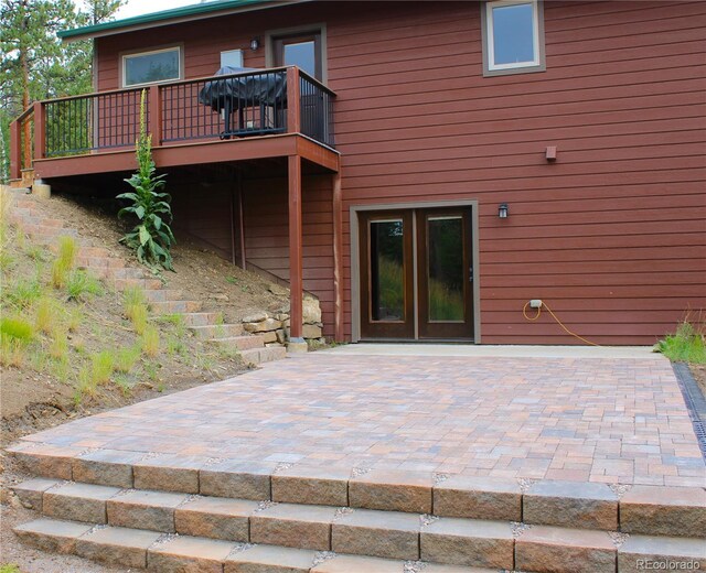 back of house with french doors, a wooden deck, and a patio area