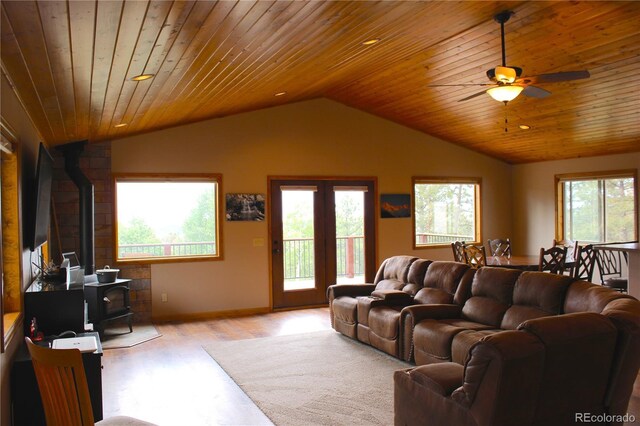 living room featuring light wood-type flooring, wood ceiling, lofted ceiling, and a wood stove