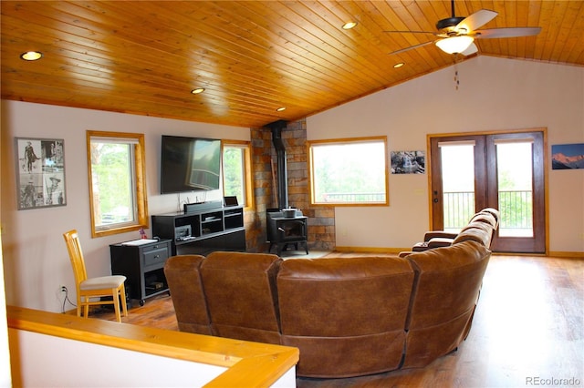 living room with wooden ceiling, a healthy amount of sunlight, light wood-type flooring, and a wood stove