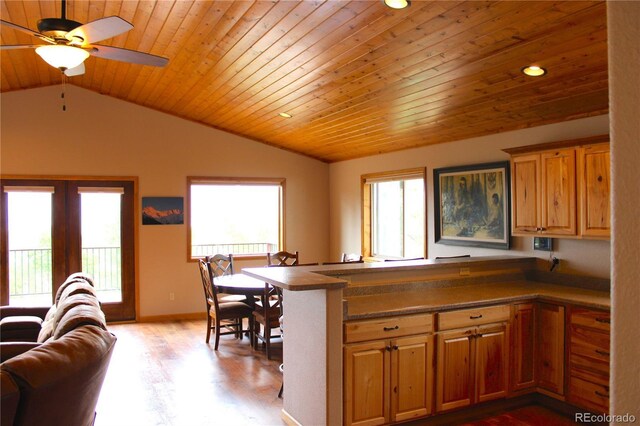 kitchen with light wood-type flooring, wood ceiling, lofted ceiling, kitchen peninsula, and ceiling fan