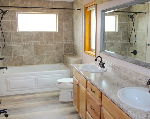 full bathroom featuring vanity, toilet, tiled shower / bath combo, and wood-type flooring