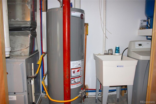 utility room featuring gas water heater and sink