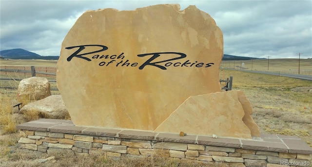 community / neighborhood sign with a mountain view and a rural view