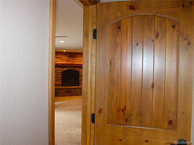 hallway featuring wood walls and carpet flooring