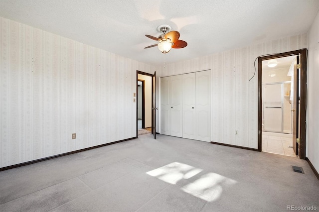 unfurnished bedroom featuring a textured ceiling, a closet, and ceiling fan