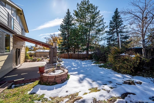 yard covered in snow featuring a patio and an outdoor fire pit