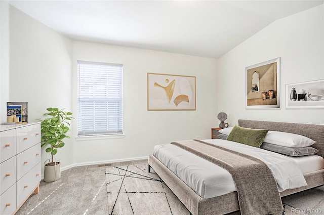 bedroom featuring light carpet and lofted ceiling