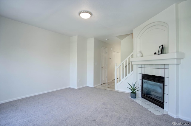 unfurnished living room featuring a tile fireplace and light carpet