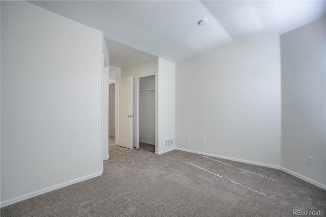 unfurnished bedroom featuring carpet flooring and vaulted ceiling