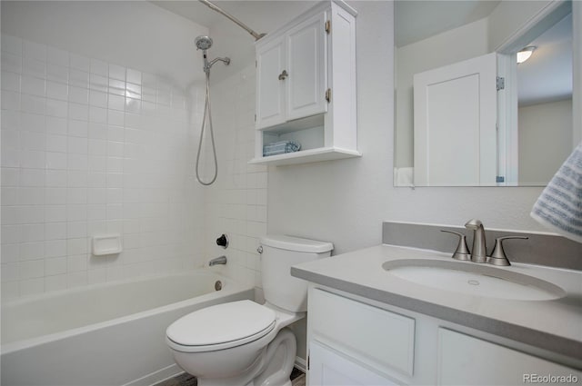 full bathroom with vanity, tiled shower / bath combo, and toilet