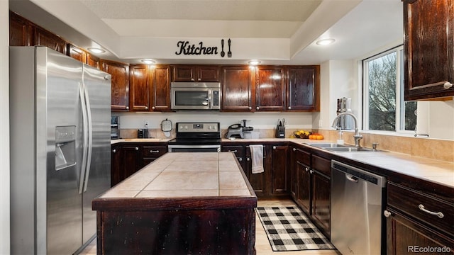 kitchen with a sink, dark brown cabinetry, tile countertops, and stainless steel appliances