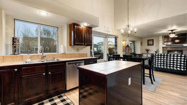 kitchen featuring tile countertops, a sink, dark brown cabinetry, dishwasher, and light wood-type flooring