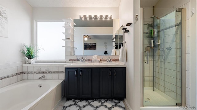 bathroom featuring a bath, a stall shower, and a sink