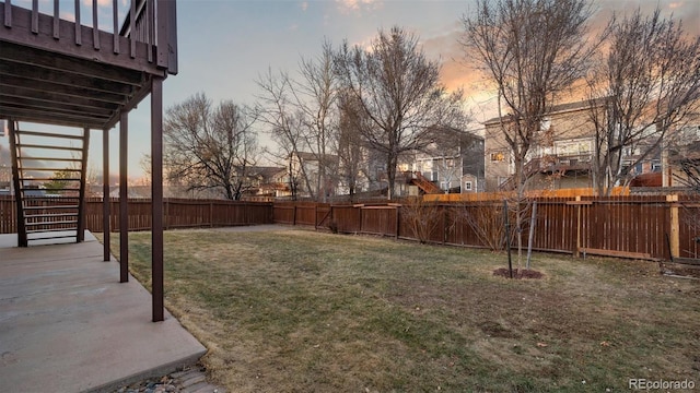 yard at dusk with a patio area, stairway, and a fenced backyard