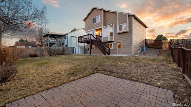 back of property with an outbuilding, a fenced backyard, a storage shed, stairs, and a patio area